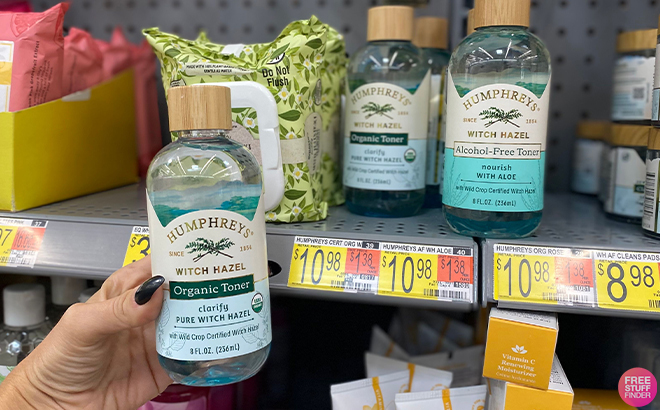 Hand Holding Humphreys Nourish Witch Hazel with Aloe Alcohol Free Toner in front of a Shelf at Walmart