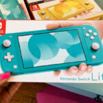 Hand Holding Nintendo Switch Lite in Turquoise Color
