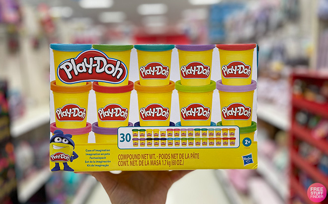Hand Holding Play Doh Case of Imagination in a Store Aisle Hand Holding Play Doh Case of Imagination in a Store Aisle