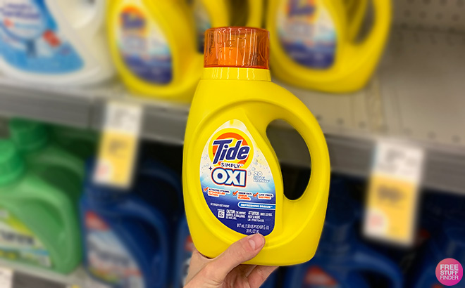 Hand Holding Tide Simply Oxi Laundry Detergent in a Store Aisle