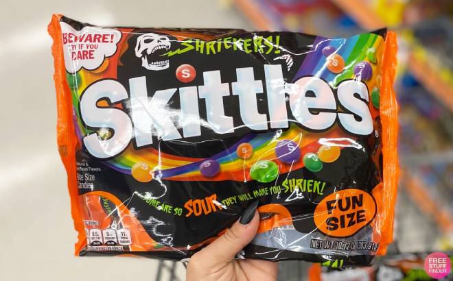 Hand Holding a Bag of Skittles Shriekers Halloween Candy