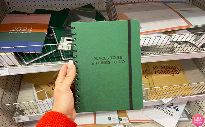Hand Holding a Planner in Green Color