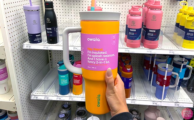 Hand holding Owala 40 Ounce Stainless Steel Tumbler Tropical Orange Hand holding Owala 40 Ounce Stainless Steel Tumbler Tropical Orange