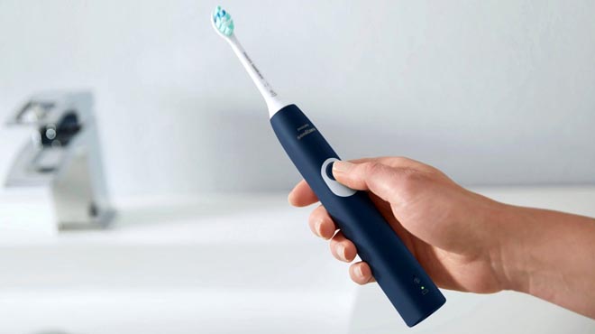 Hand holding one Philips Sonicare Electric Toothbrush Navy