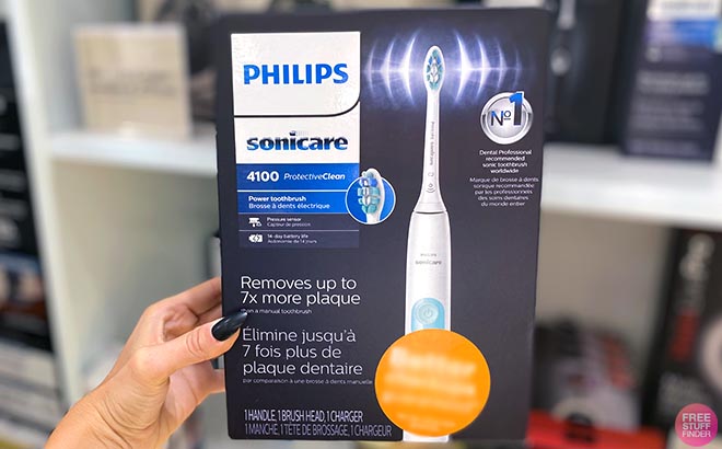 Hand holding one Philips Sonicare Electric Toothbrush