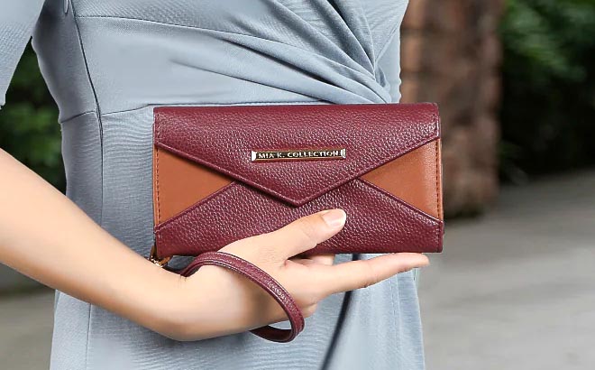 Lady holding MKF Kearny Vegan Leather Womens Wallet Bag Burgundy