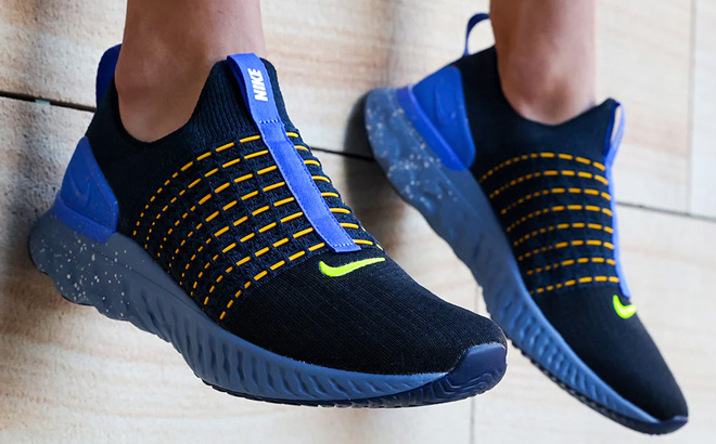 Man is Wearing Nike Mens React Phantom Run Flyknit 2 Running Shoes in Black Green and Royal Color