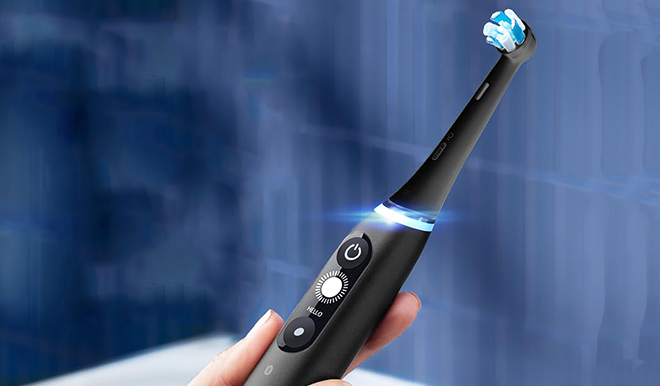 Hand Holding Oral B iO Series 7s Electric Toothbrush Black Onyx and White Alabaster 1