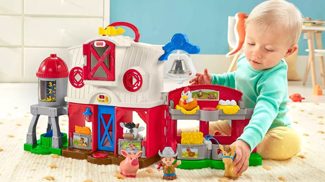 Toddler playing with Fisher Price Little People Caring For Animals Farm