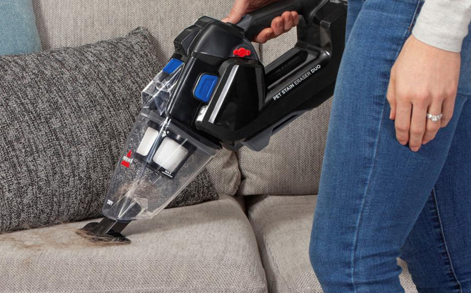 Woman Cleaning with the Bissell Pet Stain Eraser Duo Cordless Portable Deep Cleaner & Vacuum