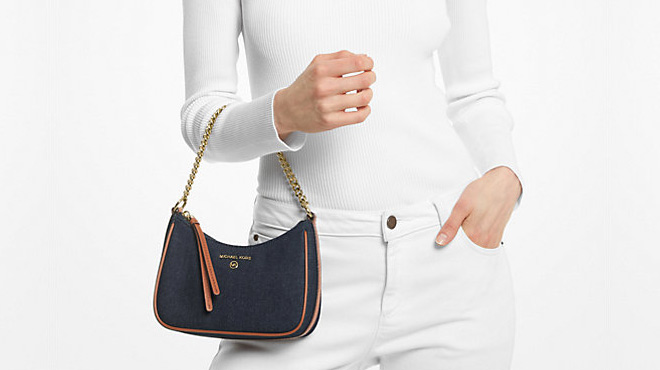Woman Holding Michael Kors Jet Set Charm Small Denim Pochette