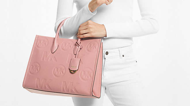 Woman Wearing Michael Kors Mirella Medium Logo Embossed Pebbled Leather Tote Bag Woman Wearing Michael Kors Mirella Medium Logo Embossed Pebbled Leather Tote Bag