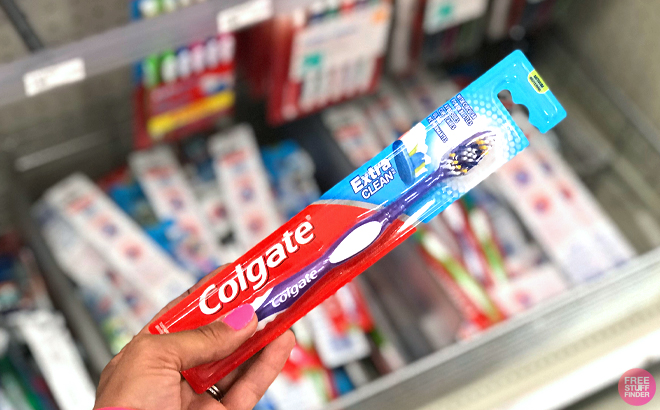 Woman holding a Colgate Extra Clean Toothbrush