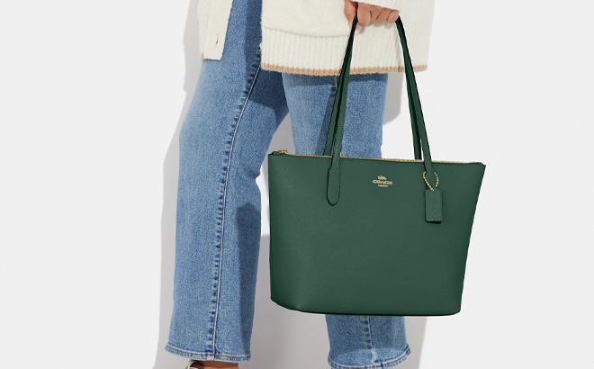 Woman is Holding Coach Zip Top Tote Bag in Dark Pine Color Woman is Holding Coach Zip Top Tote Bag in Dark Pine Color