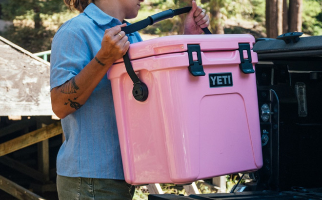 Woman is Holding YETI Roadie 24 Cooler in Power Pink Color Woman is Holding YETI Roadie 24 Cooler in Power Pink Color