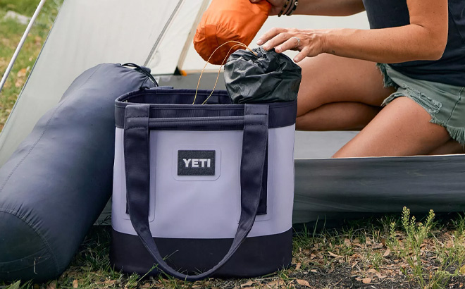 Woman is Packing Stuff in to Yeti Camino 20 Carryall Tote Bag in Cosmic Lilac Color