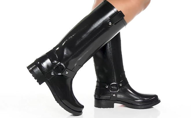 Woman is Wearing Michael Kors Womens Stormy Pull On Harness Rain Boots in Black Color