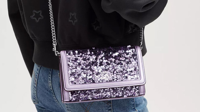 a Person Holding Coach Outlet Flap Clutch Crossbody