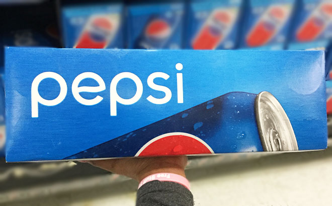 A Hand Holding a Box of Pepsi Original Cans