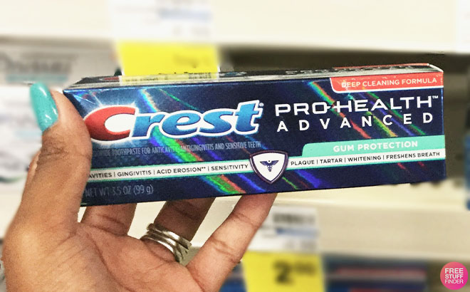 A Hand Holding a Crest Pro Health Advanced Gum Protection Fluoride Toothpaste on CVS Aisle