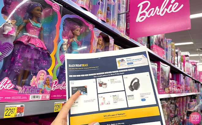 A Hand Holding a Walmart Black Friday Deals Ad on Barbie Toys Aisle