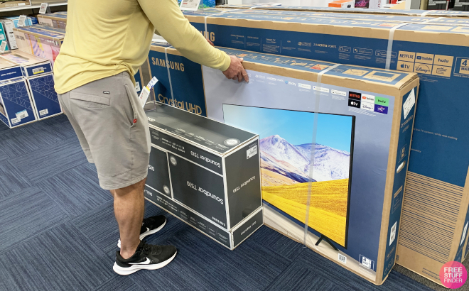 A Man Looking on a Set of Samsung TVs at Best Buy