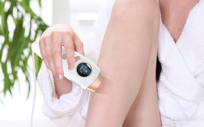 A Person Removing a Hair on Her Leg Using Laser Hair Removal Device