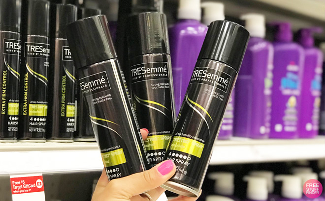 Hand Holding Three Tresemme Extra Hold Hairsprays at Target
