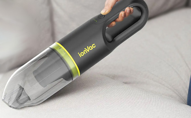 Hand Holding Tzumi Ion Vac Cordless Handheld Vacuum Cleaner in Green Color