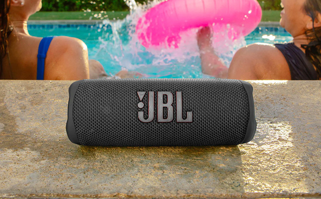 JBL Flip 6 Portable Waterproof Speaker Next to A Swimming Pool