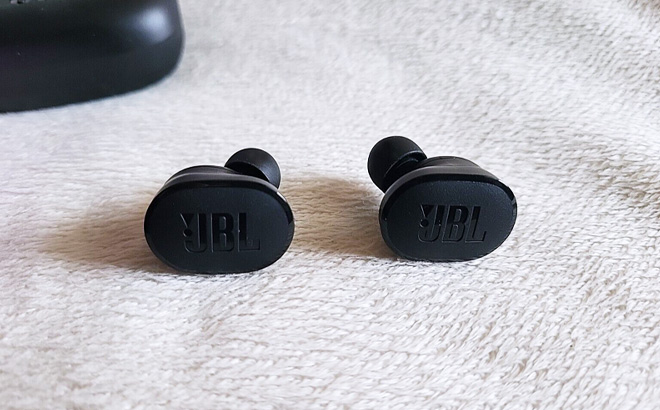 A Pair of JBL Noise Cancelling Earbuds on a Blanket