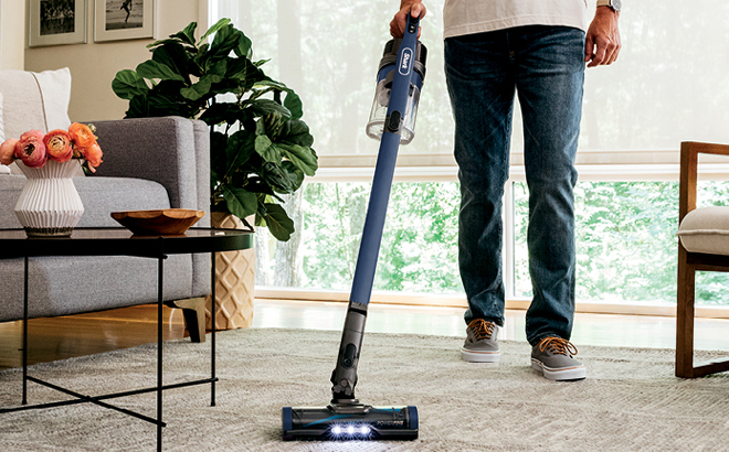 A Person Using a Shark Cordless Pet Plus Vacuum at Home