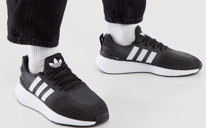 Man is Wearing Adidas Mens Swift Run 22 Running Shoes in Black White Color