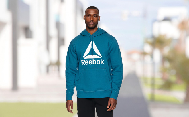 Man is Wearing Reebok Mens Delta Logo Hoodie in Blue Coral Color