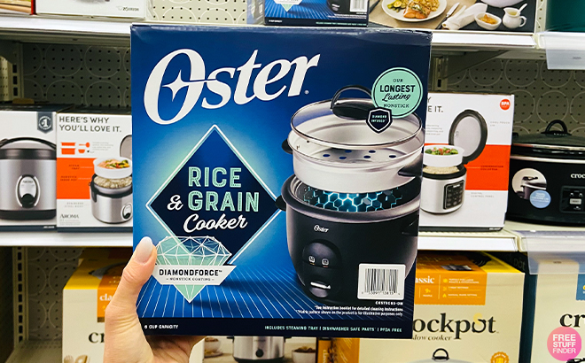 A Hand Holding an Oster 6-Cup Non-stick Electric Rice Cooker at a Store