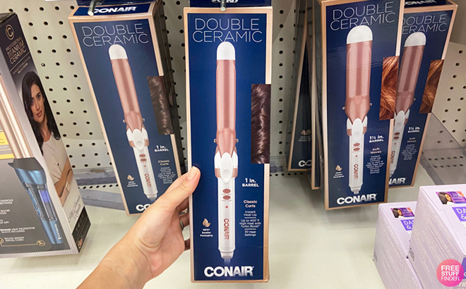 Woman holding a Conair Double Ceramic 1 Inch Curling Iron in a box