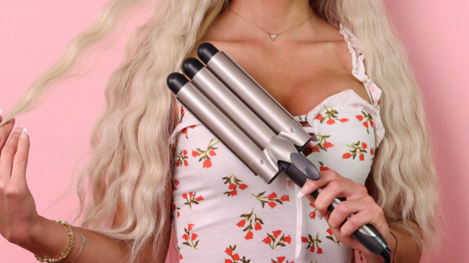 Woman holding a INFINITIPRO by CONAIR 3 Barrel Curling Iron