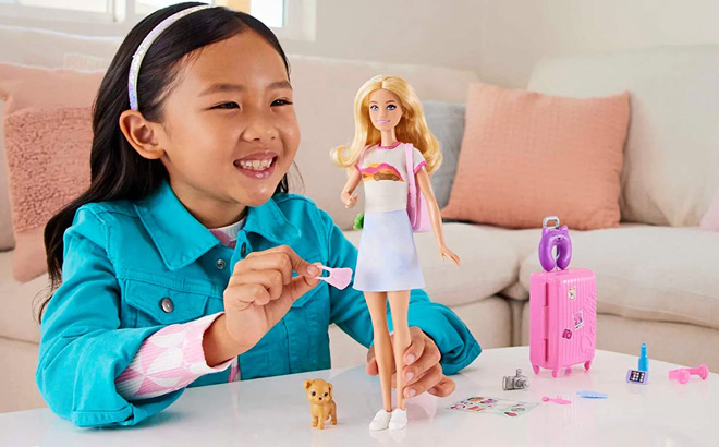 a Girl Playing with Barbie Malibu Doll Travel Set