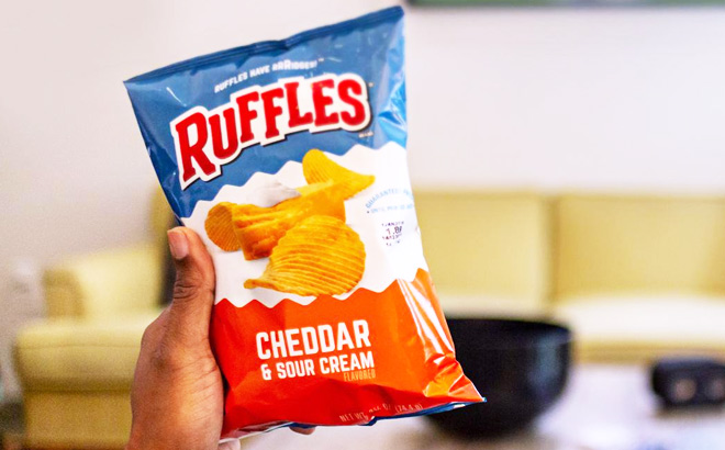 a Hand Holding Ruffles Cheddar and Sour Cream Bag