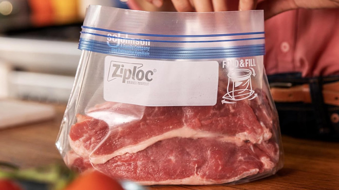 a Person Putting Meat into Ziploc Freezer Bag