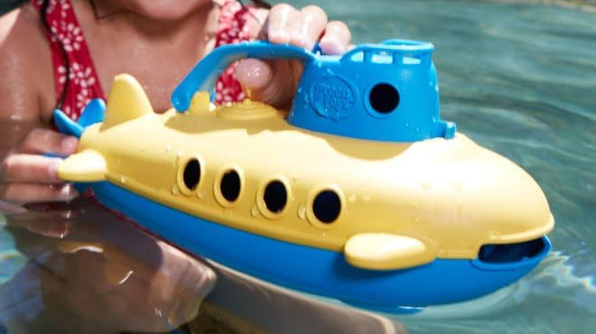 A Child Playing with Green Toys Submarine