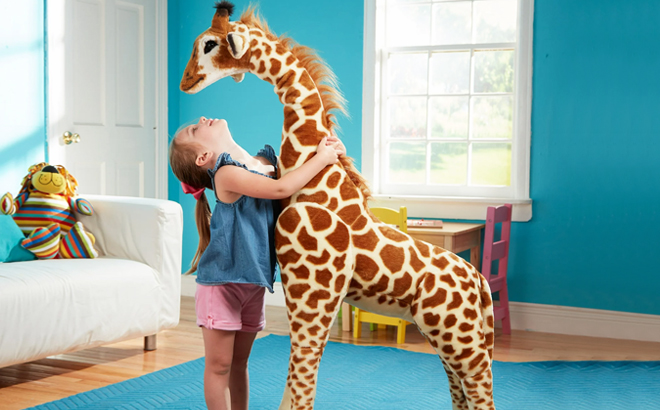 A Girl Hugging Melissa Doug Giant Giraffe Stuffed Animal