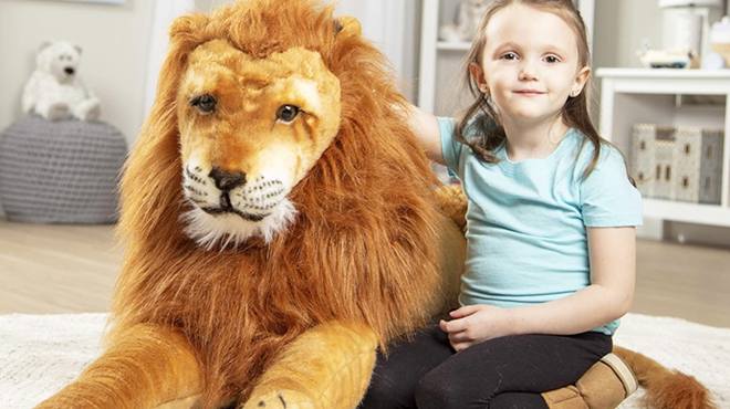 A Girl Sitting Beside Melissa Doug Giant Lion Stuffed Animal