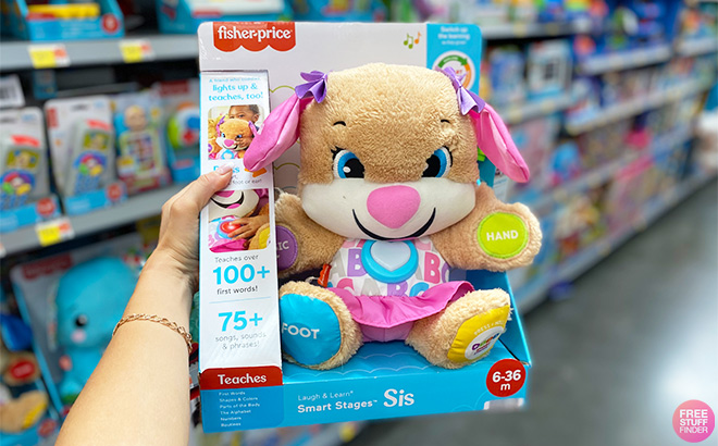 A Hand Holding a Fisher Price Laugh Learn Smart Stages Sis Plush at a Store