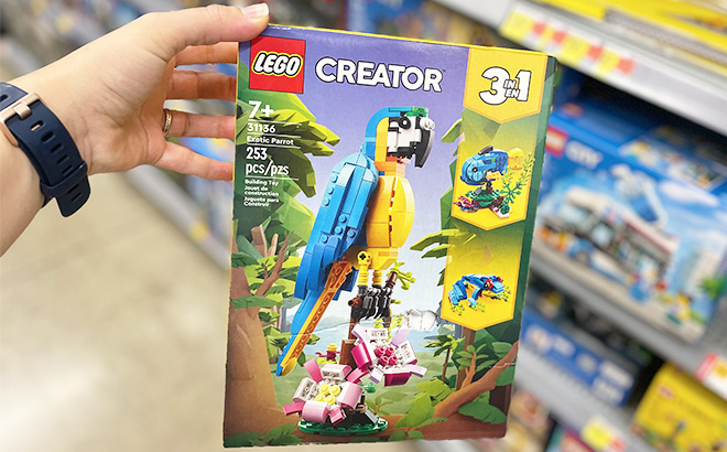 A Hand Holding a LEGO Creator 3 in 1 Exotic Parrot Set at a Store
