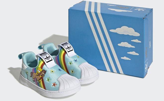 A Pair of Adidas Kids Superstar Shoes with a Box at the Background