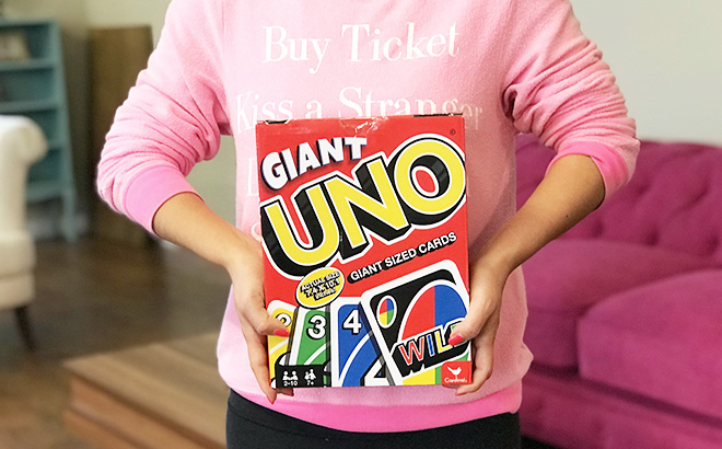 A Person Holding a Box of UNO Giant Sized Cards