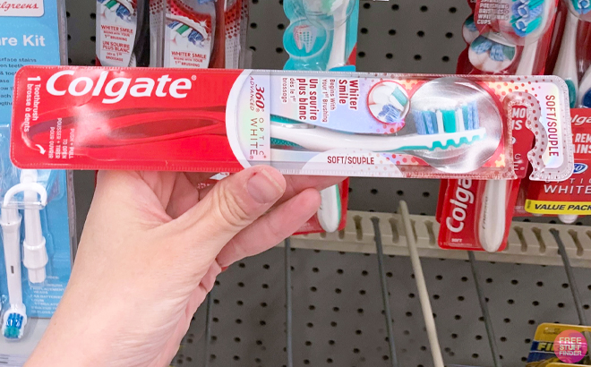 A Person holding a Colgate Optic White Whitening Toothbrush