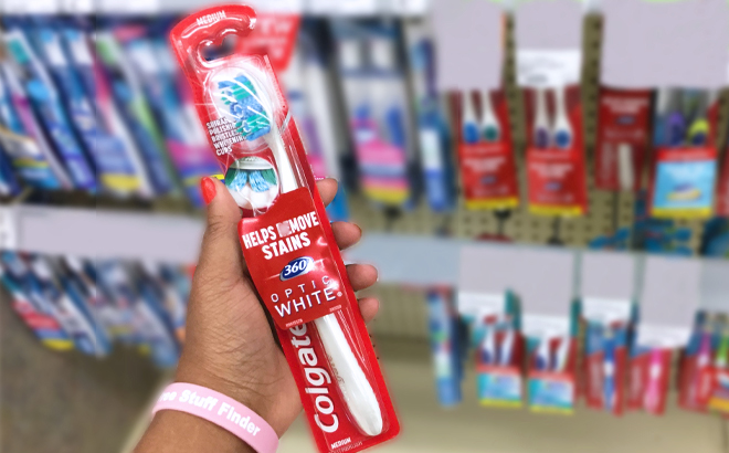 A Person holding a Colgate Whitening Toothbrush