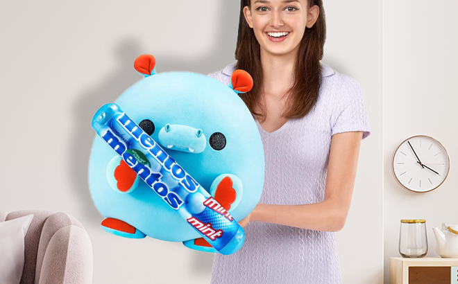 A Woman Holding Snackles Mentos Hippo Super Sized 14 inch Plush by ZURU